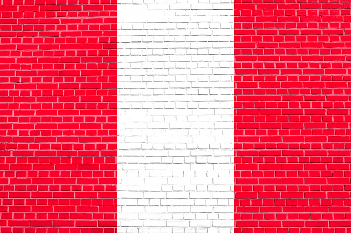 Flag of Peru on brick wall texture background. Peruvian national flag.
