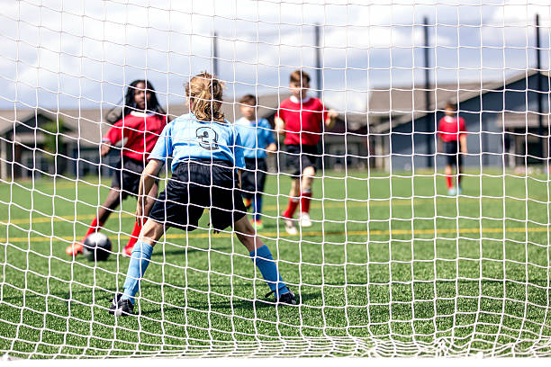 el equipo de fútbol de género mixto hace un intento de gol - campeonato deportivo juvenil fotografías e imágenes de stock