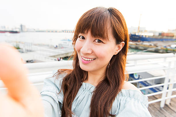 istock young Asian woman using smartphone, closeup portrait. 595320100