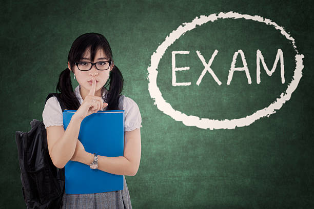 istock Student makes silence sign with Exam word 595321276