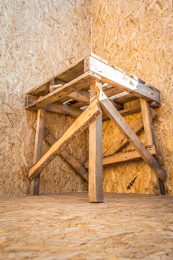Wooden building workbench standing in the corner of a building under construction