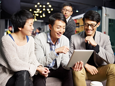 jóvenes de negocios asiáticos que usan tabletas en la oficina photo