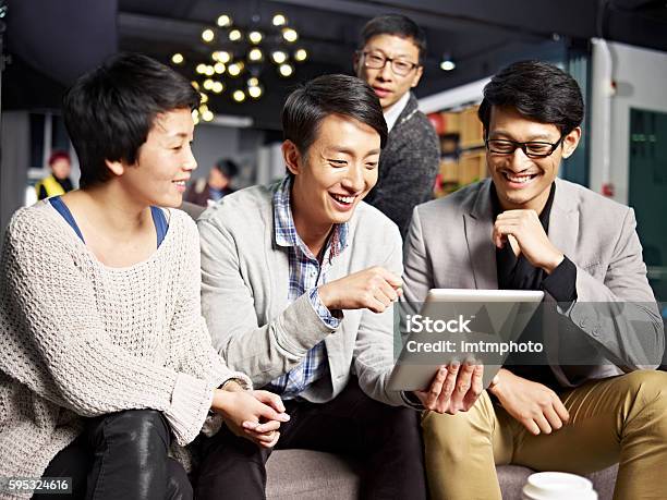 Jóvenes De Negocios Asiáticos Que Usan Tabletas En La Oficina Foto de stock y más banco de imágenes de Japonés - Oriental