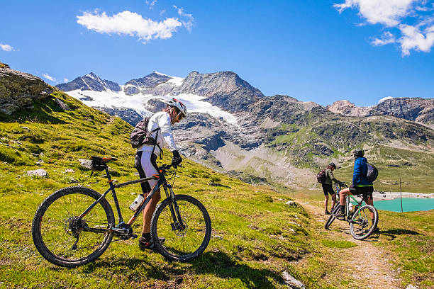 istock Hikers with mountain bike in a mountain valley 595325320