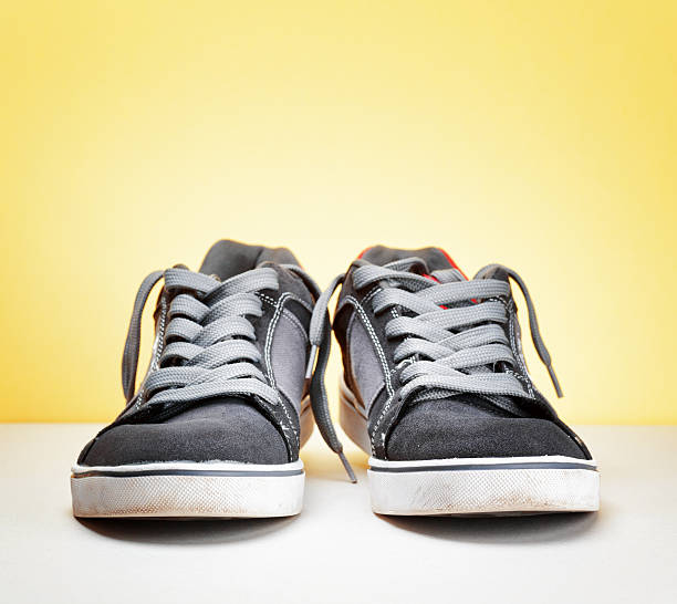 istock Pair of grey sneakers on colorful background 595325784