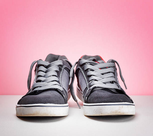 istock Pair of grey sneakers on colorful background 595326160
