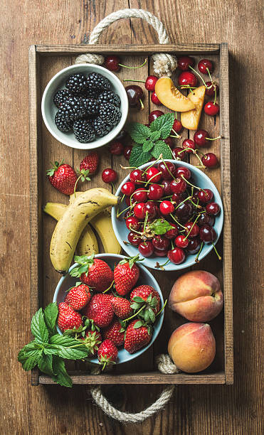istock Summer fresh fruit and berry variety in rustic wooden tray 595328976