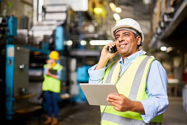 Communicating by radio Smiling worker with radio controlling the work process reflective clothing photos stock pictures, royalty-free photos & images