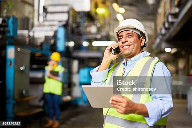 Communicating By Radio Stock Photo - Download Image Now - Latin American and Hispanic Ethnicity, Blue-collar Worker, Construction Industry