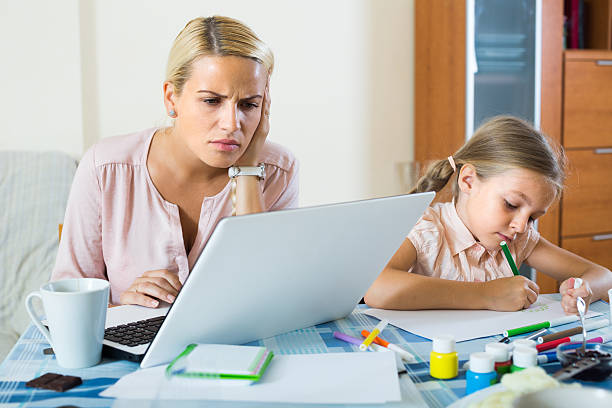 istock Stressed woman with child working from home 595330068