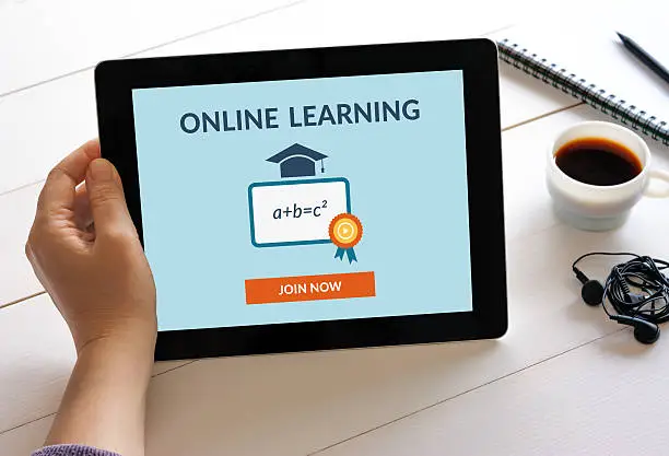 Photo of Hand holding tablet computer with online learning concept on screen