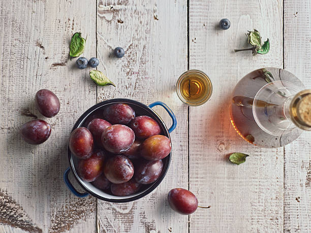 istock Traditional serbian plum brandy and plums on wooden table. 595330168