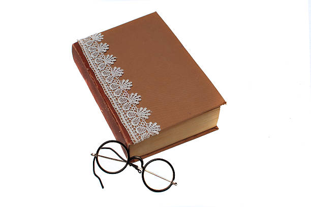istock Old book and vintage round reading glasses 595330918