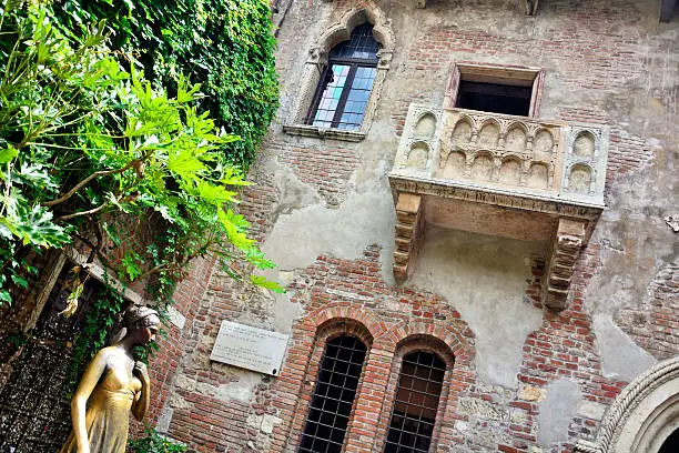 Courtyard and balcony of the Juliet's house from "Romeo and Juliet" by W. Shakespeare, Verona, Italy. Statue was created in 60s in 20 century by Italian sculptor Nereo Costantini (1905-1969)