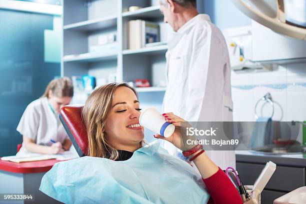 Young Woman Is Taking A Glass Of Water At Dentists Stock Photo - Download Image Now