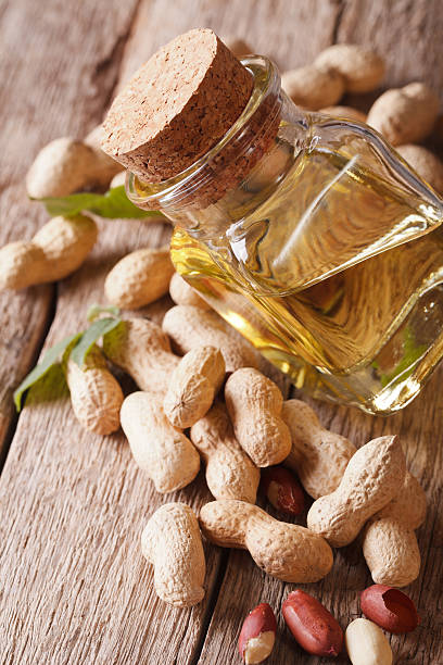 istock Healthy peanut oil in a jar macro. Vertical 595334860