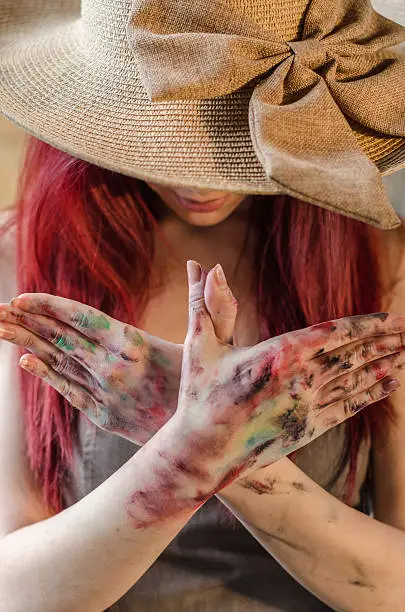 Photo of Girl artist showing dirty hands, painter copies gestures with hi