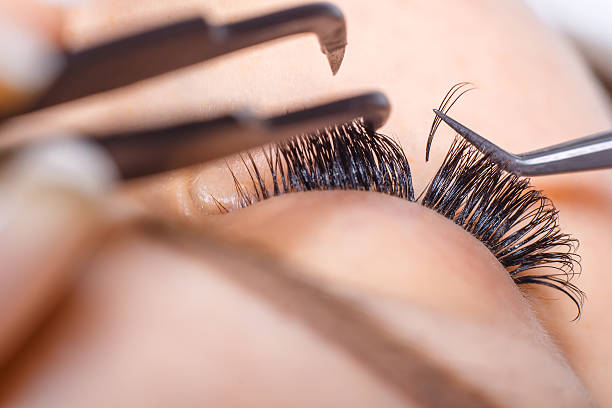 Eyelash Extension Procedure. Woman Eye with Long Eyelashes. Lashes. Eyelash Extension Procedure. Woman Eye with Long Eyelashes. Lashes. Close up, macro, selective focus false lashes stock pictures, royalty-free photos & images