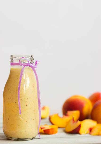 Peaches and smoothie on wooden table