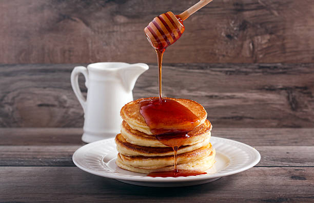 istock Honey stick pouring honey 595347404