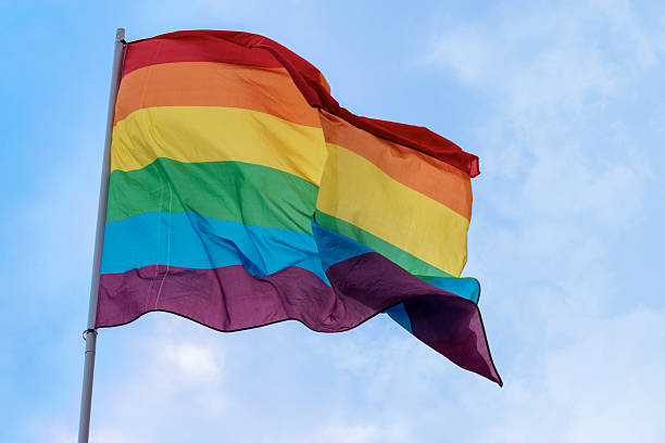 istock rainbow flag against the blue sky, homosexual rightsl 595347606