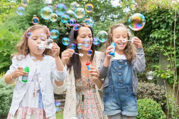 matka i córki bąbelkami na podwórku - bubble wand child blowing asian ethnicity zdjęcia i obrazy z banku zdjęć