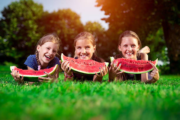 istock Three cute girls eating watermelon 595348776