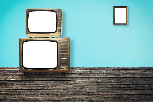 istock Old Televisions on wooden floor and photo frame on wall 595349504