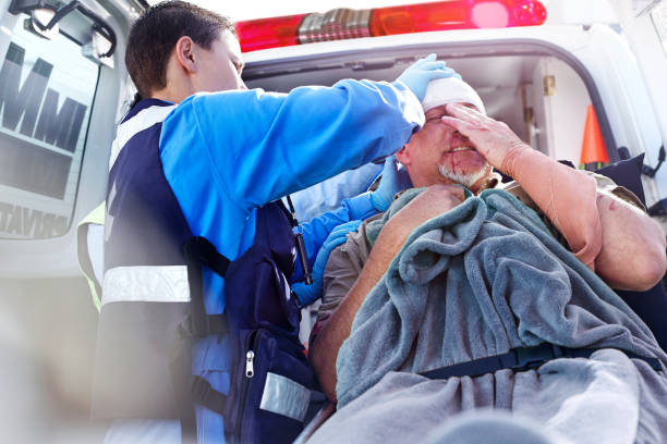 спасатель ухаживает за пациентом в задней части машины скорой помощи - телесное повреждение стоковые фото и изображения