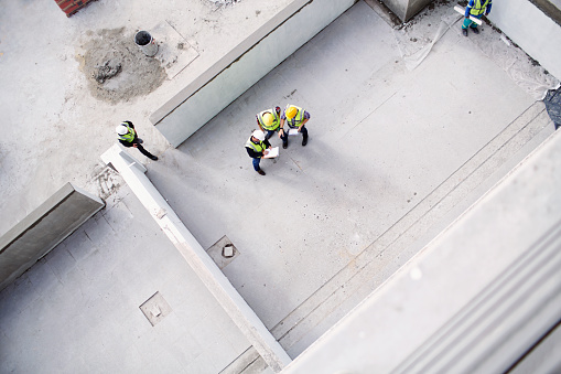 Vista aérea de los trabajadores de la construcción y los ingenieros en el sitio de construcción photo