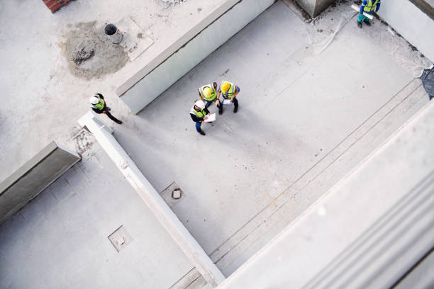 overhead view of construction workers and engineers at construction site - construction site imagens e fotografias de stock