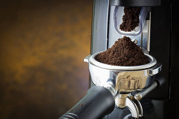 istock coffee grinder grinding freshly roasted coffee beans into a coff 595350486