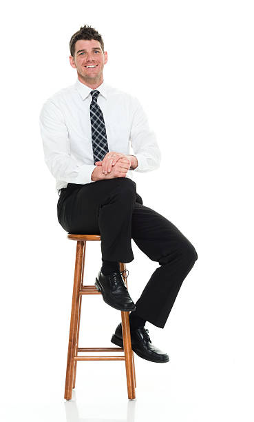istock Smiling businessman sitting on stool 595351424