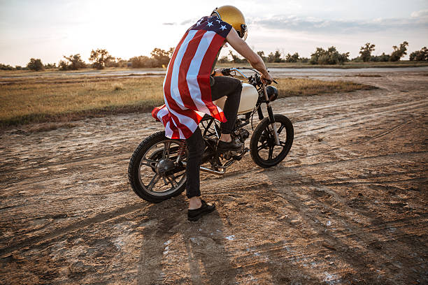 istock Man in golden helmet starts his motorcycle 595352284