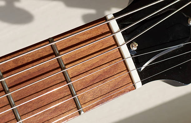 istock guitar neck and frets. strings shadow on the wood 595353588