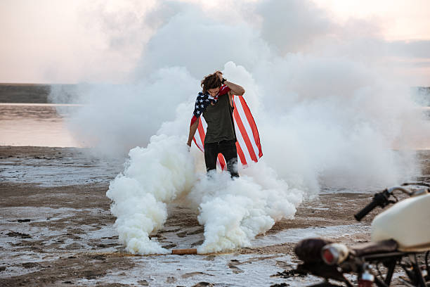 istock Brutal man wearing usa flag cape posing in white smoke 595353936