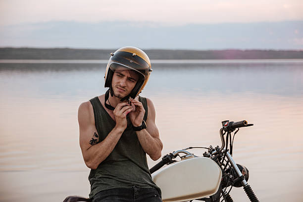 istock Man tries to put off his helmet sitting on motorcycle 595354916