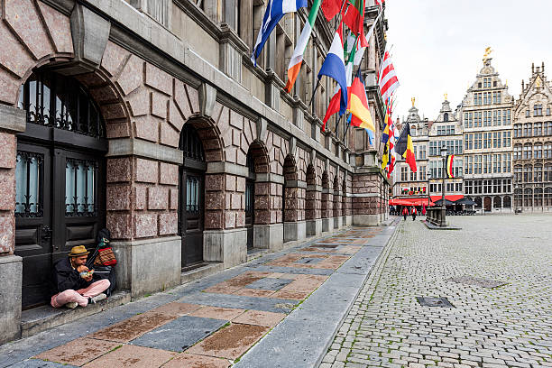 Antwerp, Belgium - July 1, 2016: Homeless eating food front door on the Great Market Square of Antwerp, Belgium.