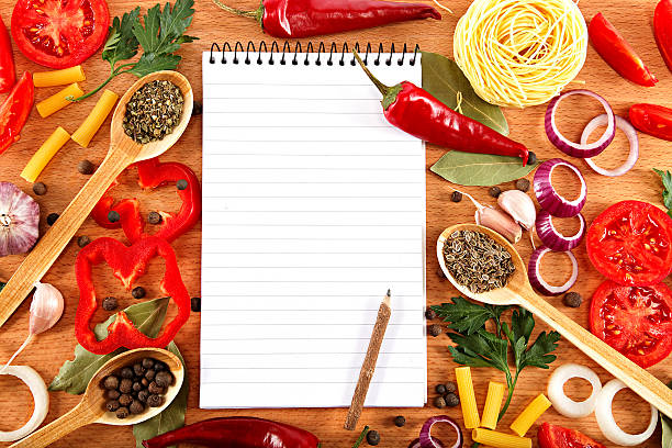 istock Vegetables, spices and recipes notepad on wooden cutting board. 595359914