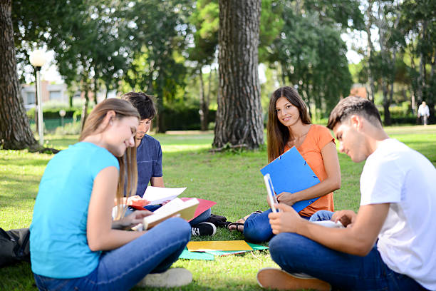 istock group students sitting together on lawn high school university campus 595360982