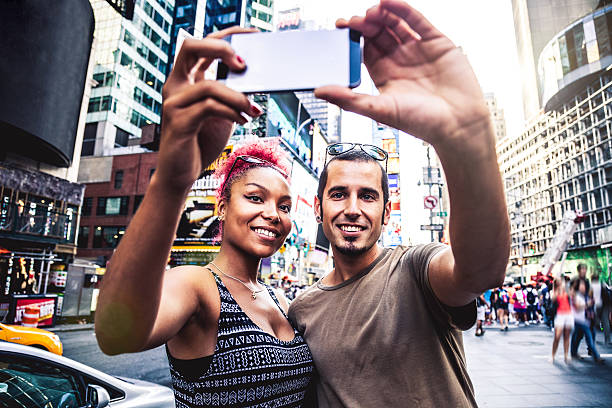 istock Tourist couple take a selfie in Times Square 595362644