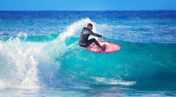 uomo giovane surfista surf sulla spiaggia di isola di kauai, hawaii - surfing surf wave men foto e immagini stock
