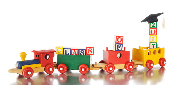 A child's colorful wooden train pulling alphabet blocks arranged to say, 