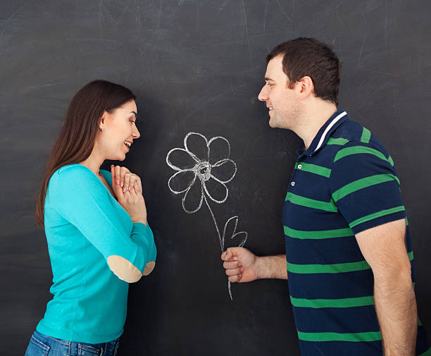 istock Young happy couple with daisy flower. Chalk drawing 595366706