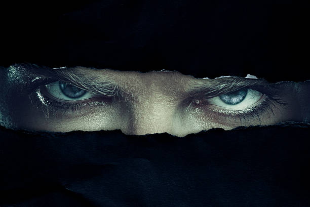 Eyes Angry man looking through a hole evil stock pictures, royalty-free photos & images
