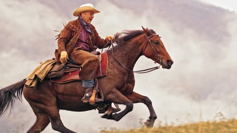 SLO MO DS Rancher riding uphill on horse in gallop