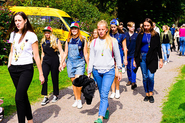 Lund, Sweden - August 24, 2016: Group of female student sponsors (fadder) and students walking by in public park on their way to an event.