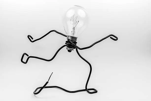 Emotional fantasy figure of a transparant light bulb and black electrical wires.