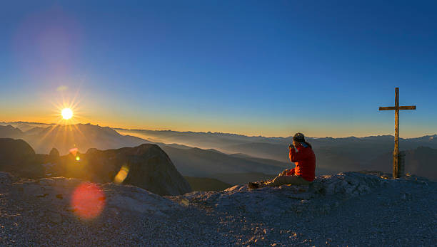 mountain climber enjoy the sunrise at mountain peak hochkönig - summit cross imagens e fotografias de stock