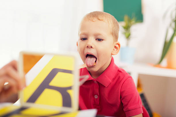 logopädin lehrt die jungen zu sagen, der buchstabe r - child speech therapy adult stock-fotos und bilder